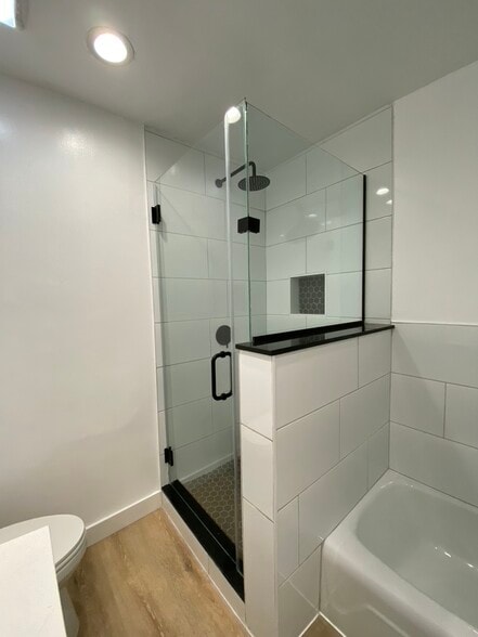 Separate porcelain bathtub and glass shower with luxurious rainfall showerhead - 1203 N Sweetzer Ave