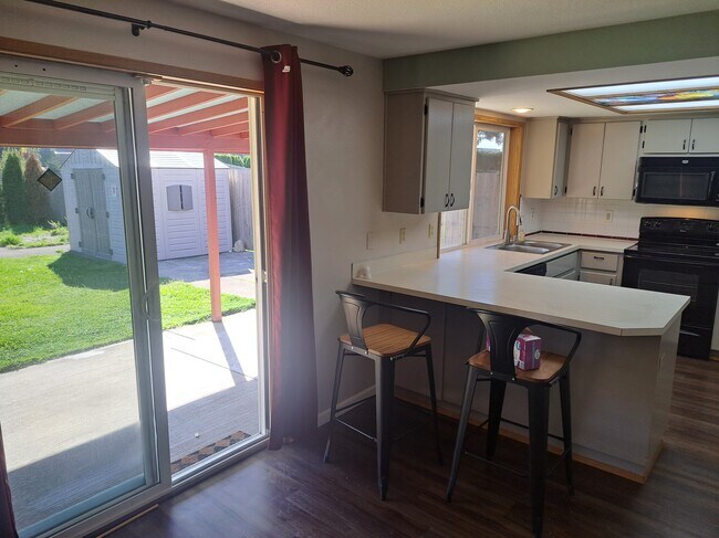 Open floor plan kitchen and living room look out onto backyard - 15815 NE 69th St