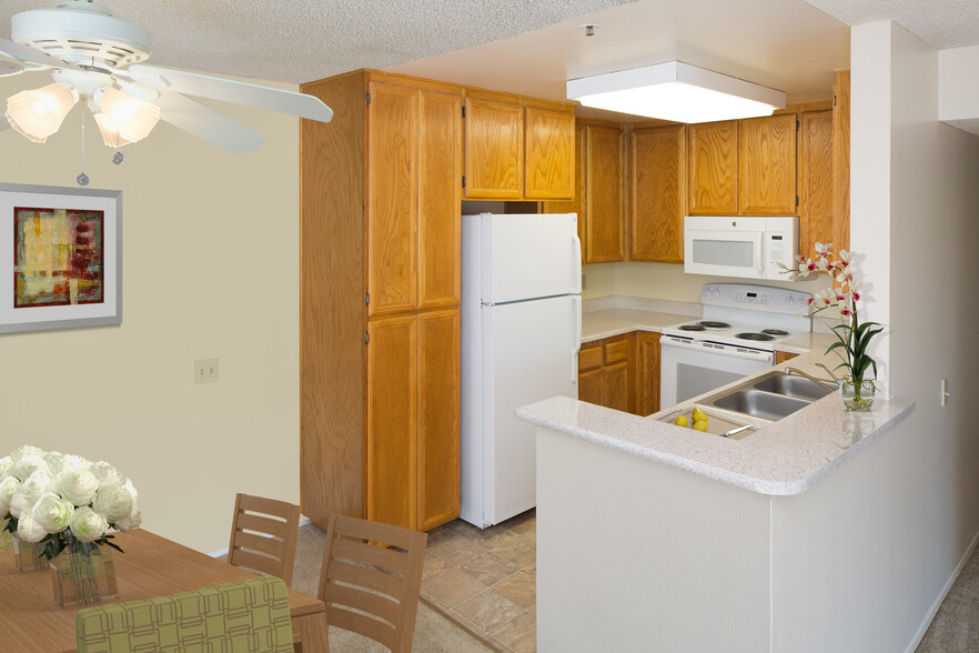 Classic Package kitchen with oak cabinetry, beige speckled laminate countertops, tile flooring, and white appliances - eaves La Mesa