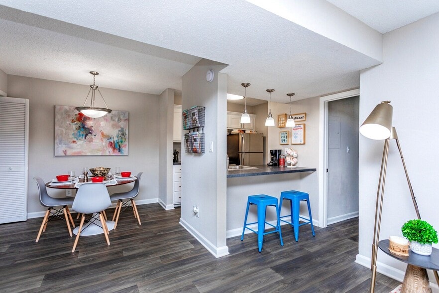 Open-concept dining space with breakfast bar and modern flooring. - Domain Apartments