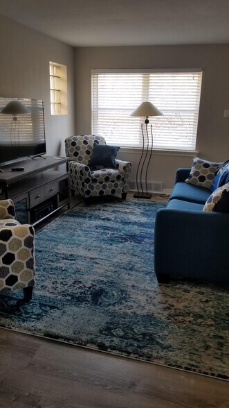 Just a portion of the living showing one seating arrangement. TV wall features to glass block windows. - 3443 Lawn Ave