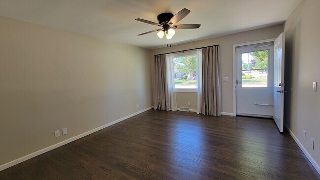 Large Living Room with refinished hardwood floors through the first floor. New ceiling fan & drapes - 6305 49th Ave