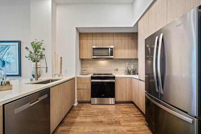 Gourmet chef-inspired kitchen with spacious island, stainless steel appliances, quartz countertops and full-height backsplash - Windsor Winchester