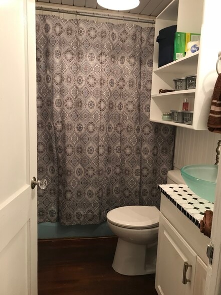 View from central hallway into updated bathroom with new toilet; large over toilet open shelving for easy access to towels or cosmetics - 1407 W Church St