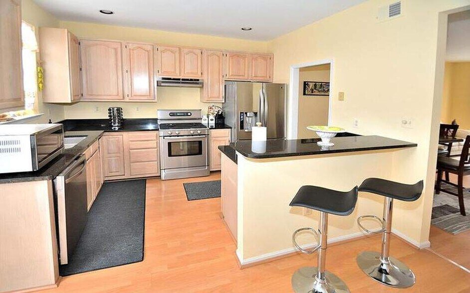 Kitchen with granite countertops and modern appliances. - 14614 Stream Pond Dr