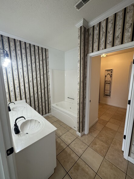 Master bath with view to laundry room. - 1701 Water Oak Dr