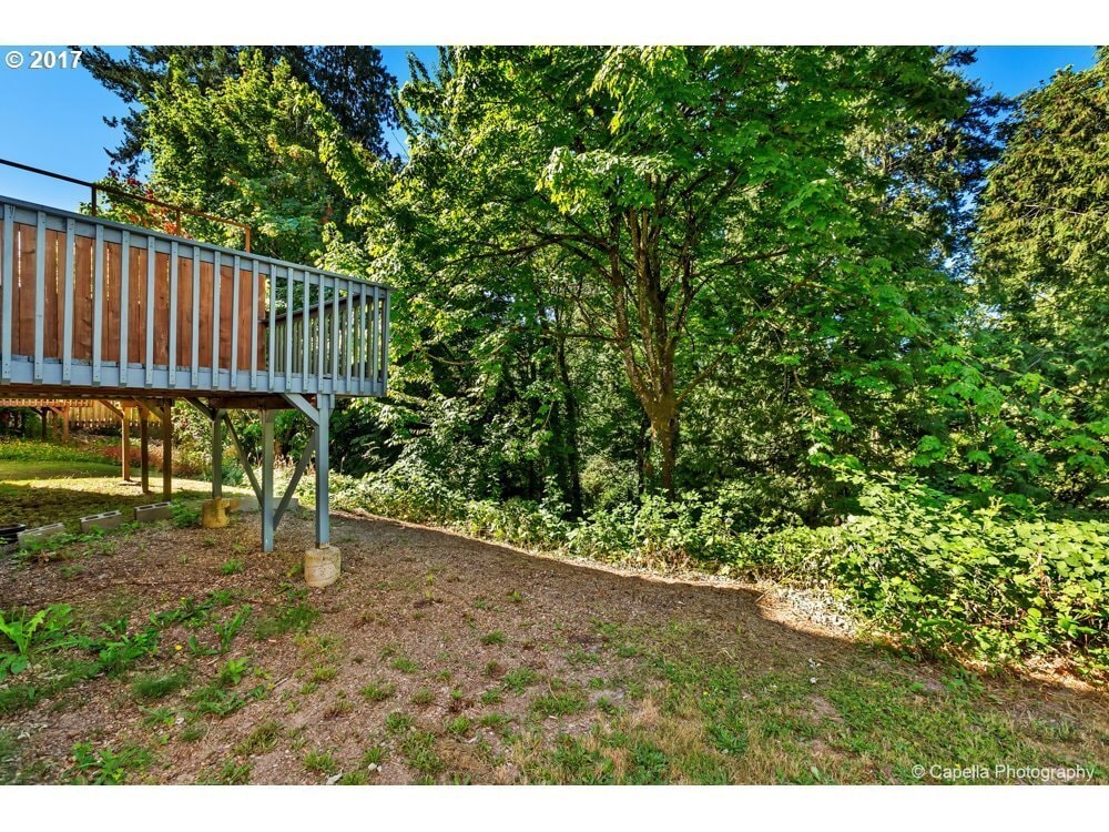 Large deck overlooking the creek offers a serene outdoor space to relax - 7414 NE Shaleen St