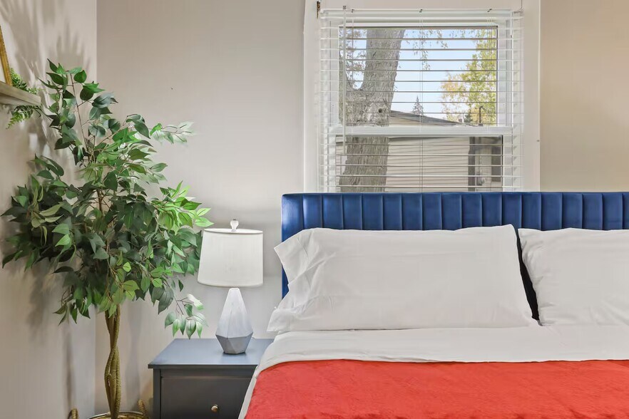 Bedroom 1 with king sized bed, sleeper couch, closet space and dedicated work table, chair and table - 1002 Juniper Ln
