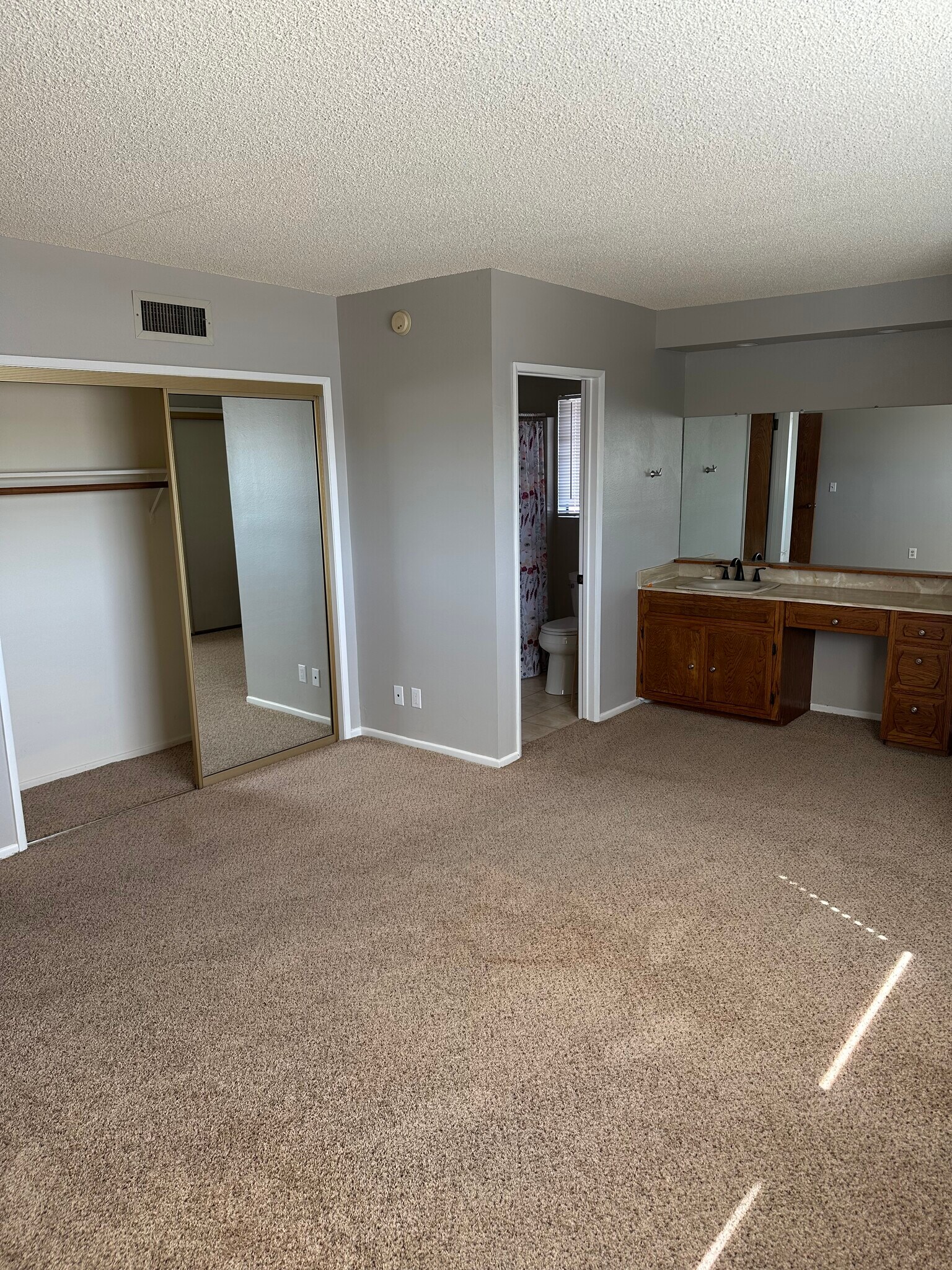 Master bedroom with double door entry and vanity in bedroom with attached bathroom - 17632 Los Alimos St