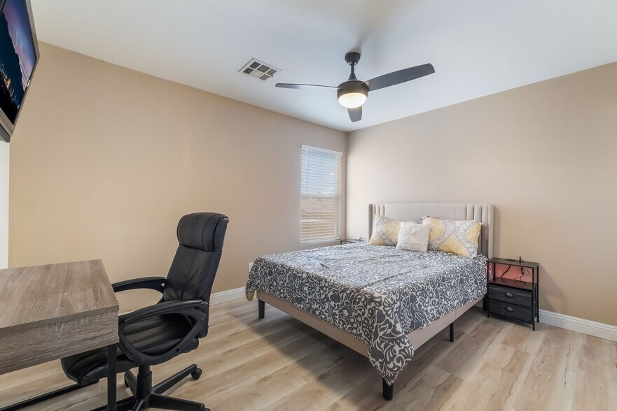 Bedroom featuring light wood-style flooring, ceiling fan, and an office area - 1179 Antoinette St