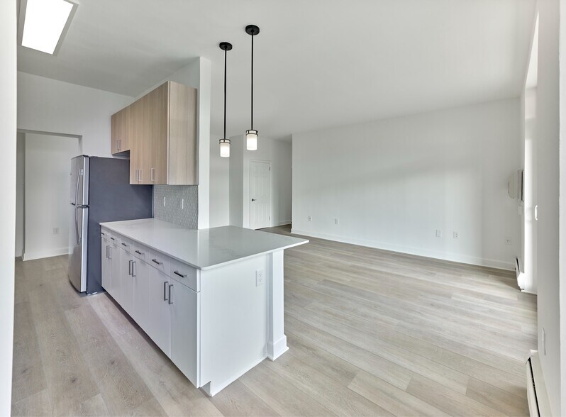 Bright and modern kitchen with quartz countertops and stainless steel appliances at Crestwood Apartments in Wayne, PA - Crestwood