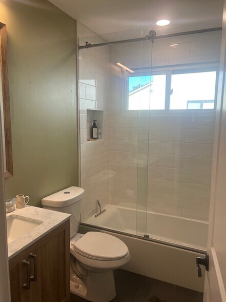 Updated bath with tiled shower and sleek modern finishes. - 953 13th Ave S
