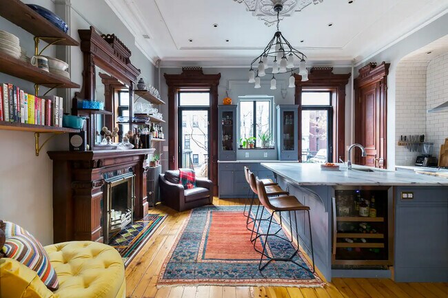 Kitchen featuring large marble island, luxury appliances, and original woodwork and moulding - 140 Halsey St