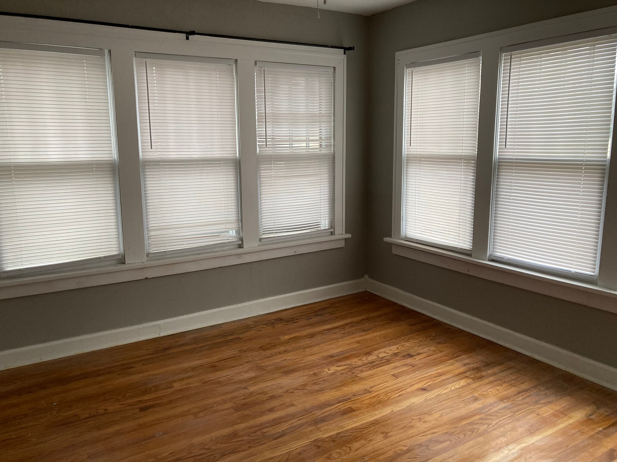 Photo of Front bedroom, all three bedrooms are painted grey and have large windows and private closet. - 1503 N Broadway Ave
