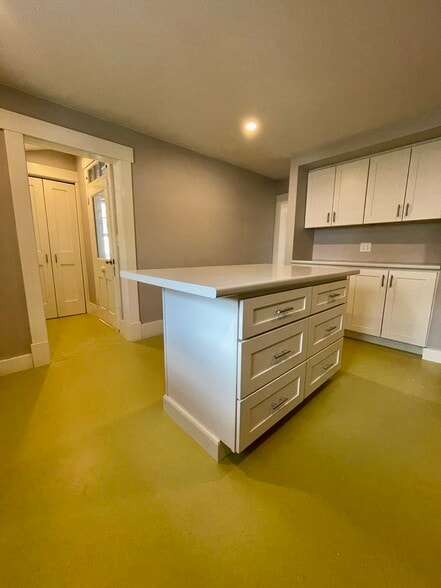 A view of the kitchen island into the hall with laundry area. - 20 Chapel St