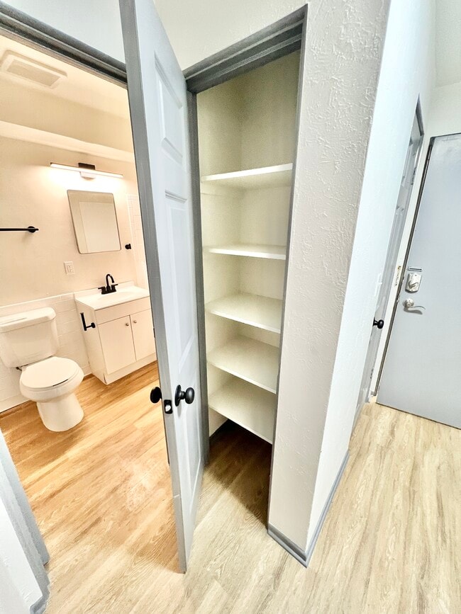 Explore the efficient design of this bathroom space, featuring practical storage solutions. - Melody Apartments