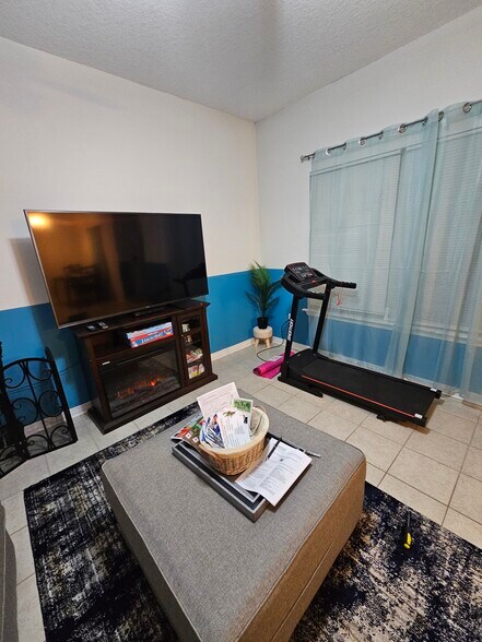 Electric fireplace and treadmill/exercise area by the window during ?? sunrise - 15913 Adam Rd