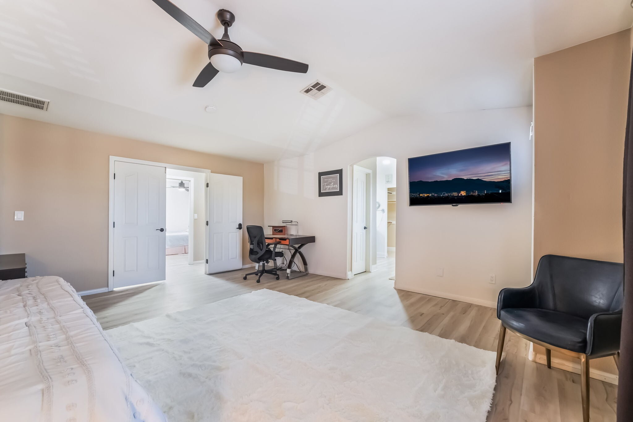 Bedroom with an office area, light wood-style floors, vaulted ceiling, and a ceiling fan - 1179 Antoinette St