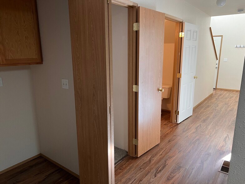 downstairs hall with laundry, closet, and half bath with front door and stairs - 5541 Glenridge Way