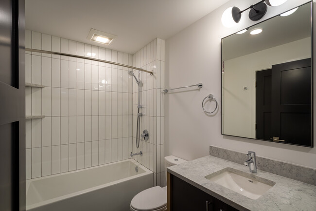 Tiled bathroom, Grohe fixtures, Toto dual flush toilet, quartz countertops, custom cabinetry - 625 Malden Ave E