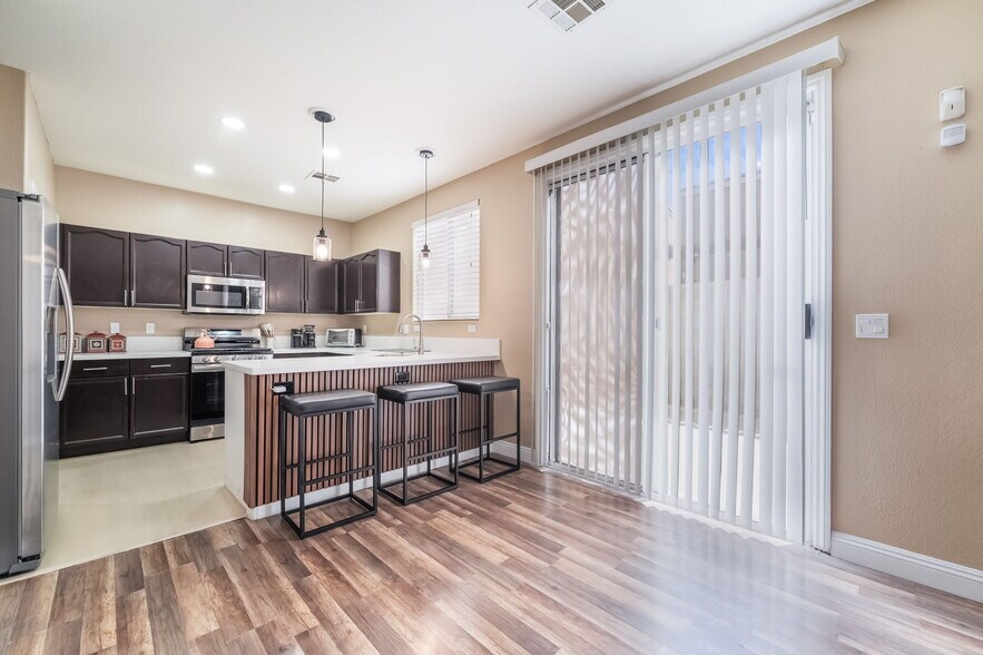 Kitchen with stainless steel appliances, a breakfast bar, pendant lighting, light countertops, and l - 1179 Antoinette St