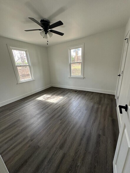 Room featuring plenty of natural light, dark wood-type flooring, and ceiling fan - 1247 N Florissant Rd