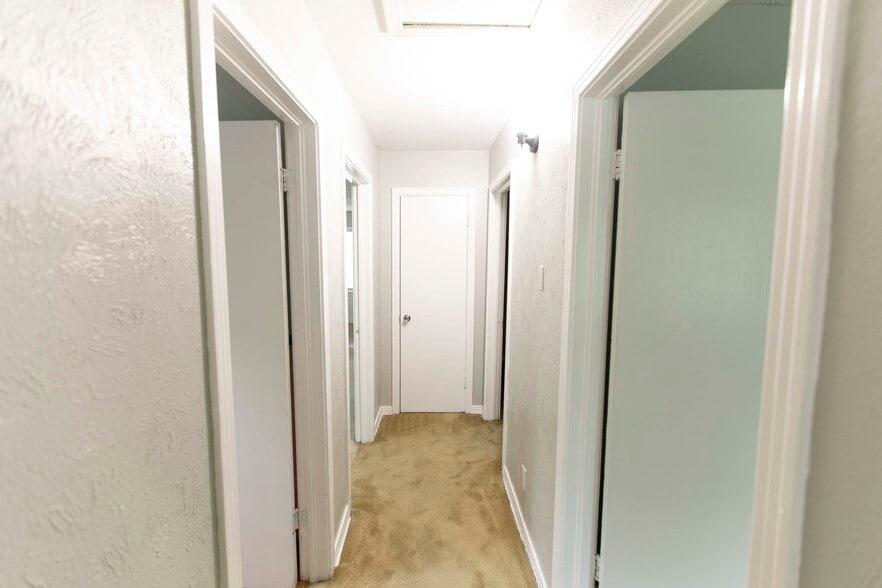 Hallway. Master on right, bathroom 1 on left (1st door), bedroom two on right (2nd door), living area 1 on left (2nd door). - 7459 Mohawk Ave