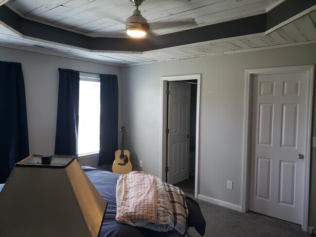 Large primary bedroom with bespoke tray ceiling with huge walk in closet and attached full bathroom. - 820 Laramie Ct