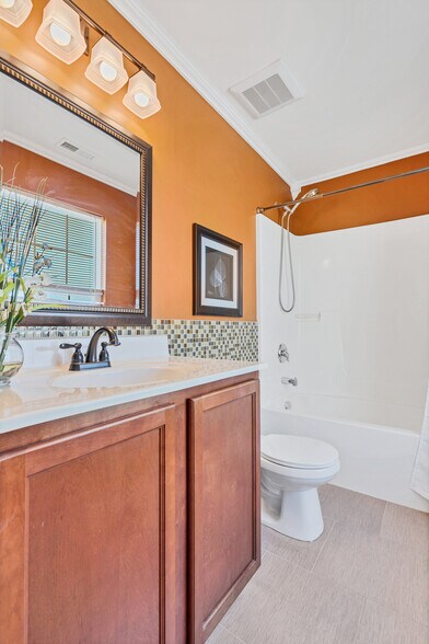 Vibrant master bathroom with tile flooring, mosaic tile wall accents and crown molding - 201 Countryshire Dr