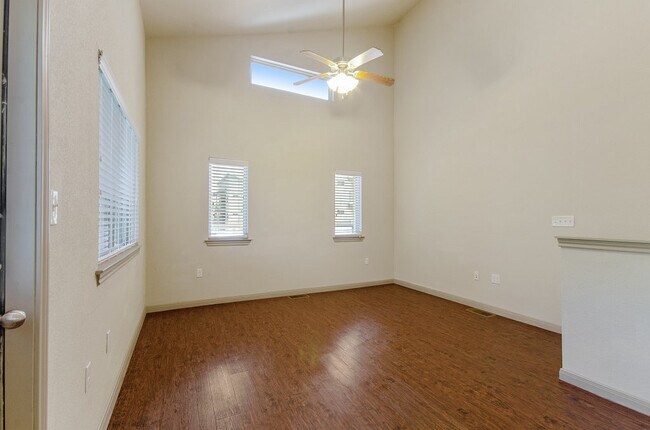 Spacious living room with ceiling fan and vaulted ceiling - Tinsley Place