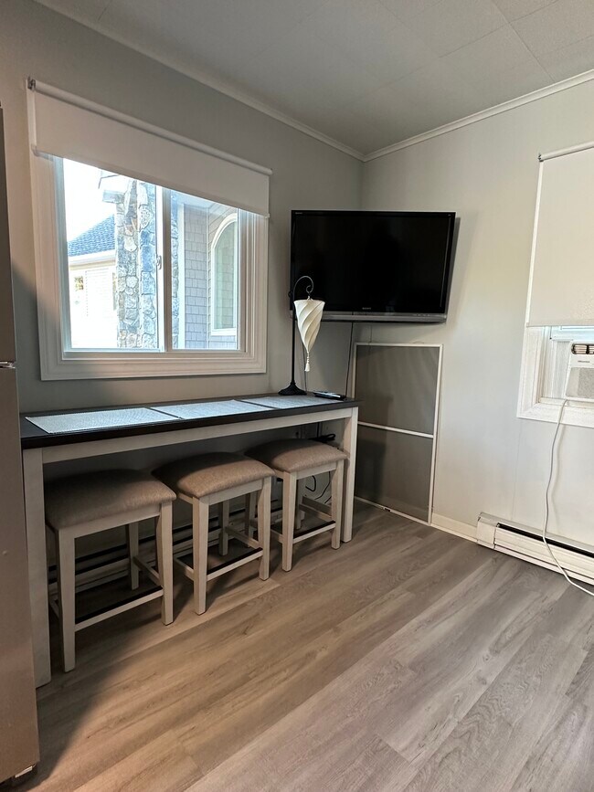 Table in living room/kitchen with windows. - 16 Crescent Beach Dr