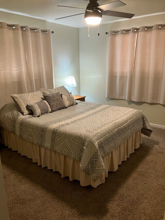 Queen bed with two night stands and a reading light - 1820 Fremont Ave