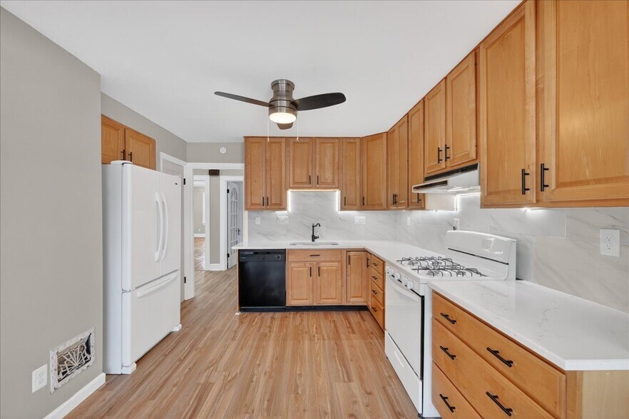 Updated kitchen with ample cabinet space and modern finishes - 5185 Goethe Ave
