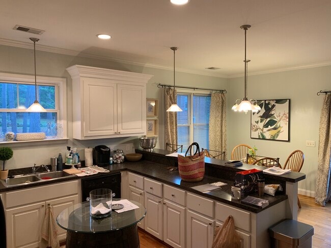 New dishwasher is stainless steel and pendants over bartop and chandelier in dining area updated. - 3406 Margrave Rd