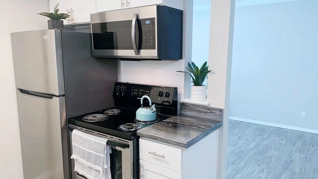 Our chic studio apartments feature a separate kitchen area with modern finishes, combining functionality with style. - Lakewood Village