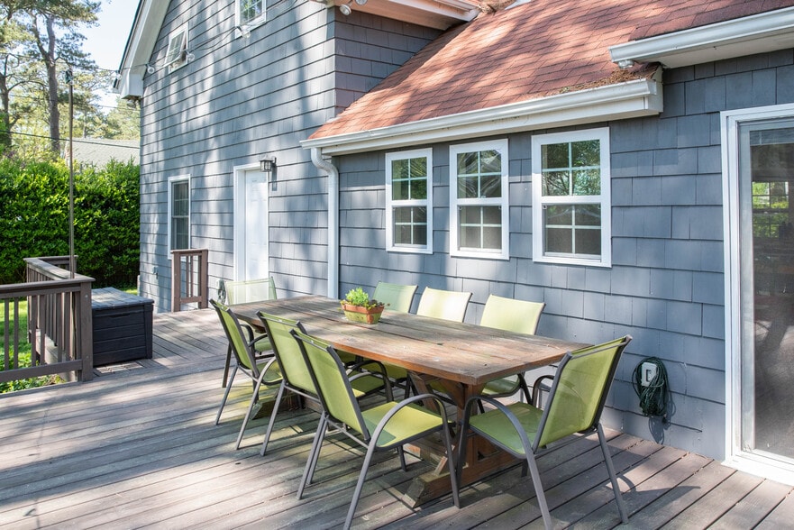 Outdoor Farmhouse table ad green mesh dining chairs stay with the home. - 417 E Government Ave