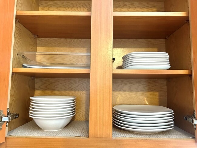 Fully stocked kitchen with dishes and bowls. - 6464 Starfish Cv