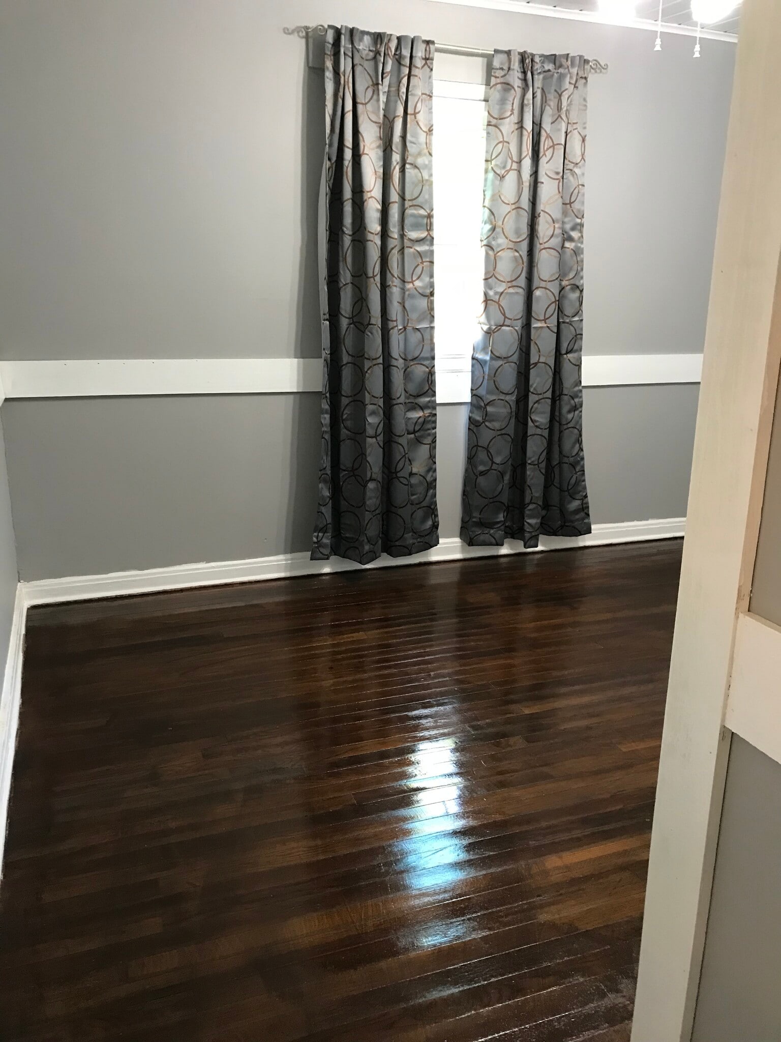 MBR entrance from central hallway reveals refurbished original red oak floors; wainscoting adds modern accent - 1407 W Church St