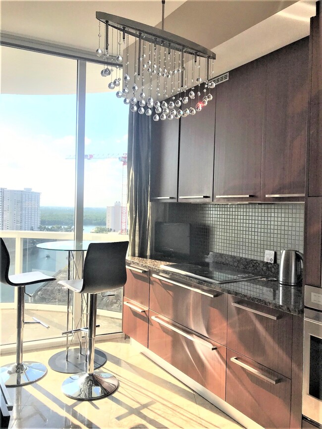 Kitchen with European Cabinetry and crystal chandeliers - 15901 Collins Ave