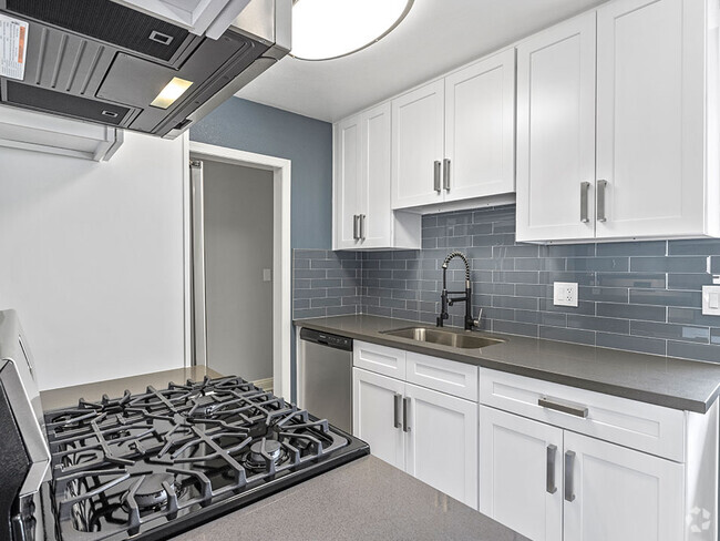 Kitchen with blue tile backsplash and stainless steel Stove, Oven, and fixtures. - Rose Avenue