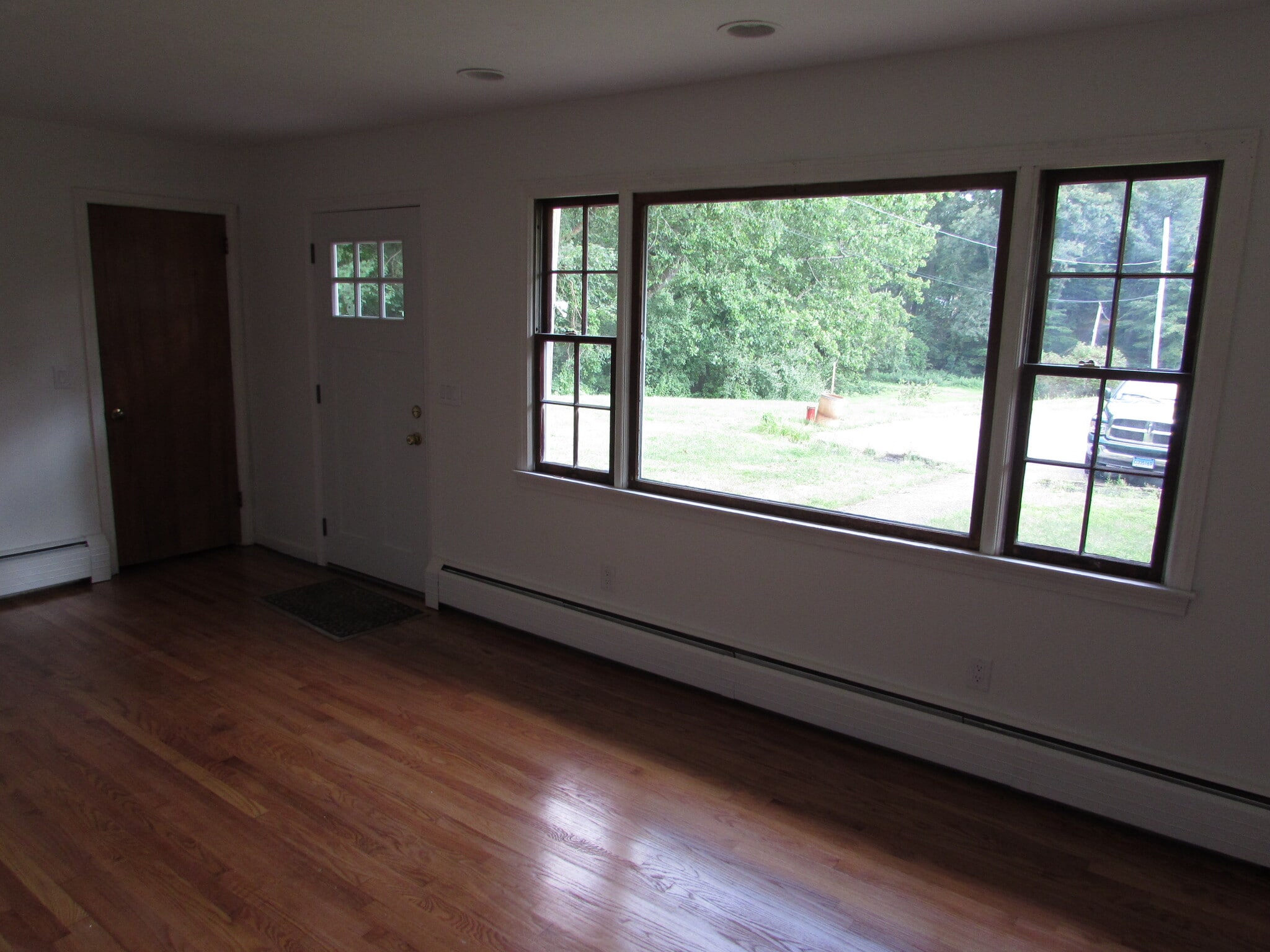 Living room entry door and picture window as seen from the fireplace - 97 Scrub Oak Rd