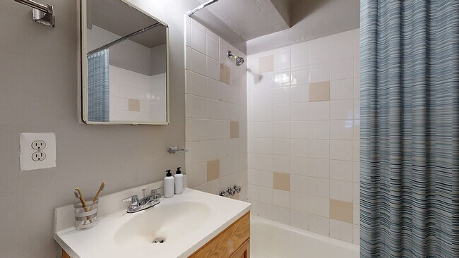 Experience modern comfort in this stylish bathroom with a refreshing shower space. - Harmony Apartments