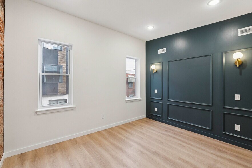 Primary bedroom with exposed brick and bedside lighting - 1544 S Bambrey St