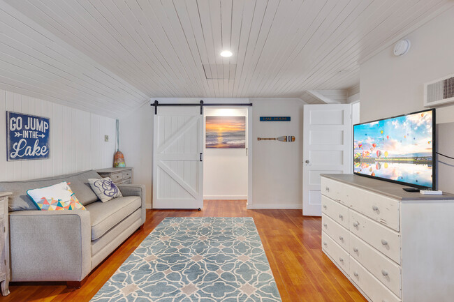 Upstairs bunk room with couch that has a pull out bed. Large flat screen TV. - 717 E Lakeside Ave