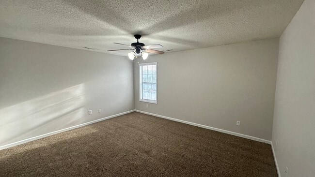 Master bedroom has a ceiling fan and carpet. - 1211 Goldridge Dr SW