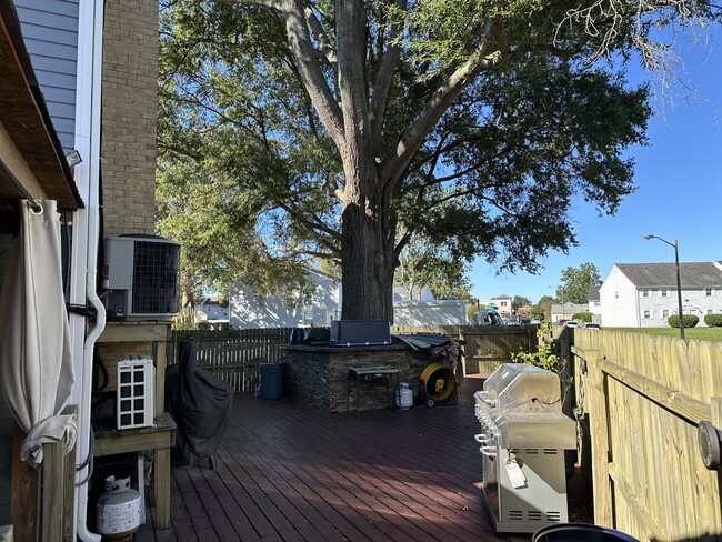 More of backyard with deck and wrapped around breakfast nook around tree - 3613 Harbinger Rd