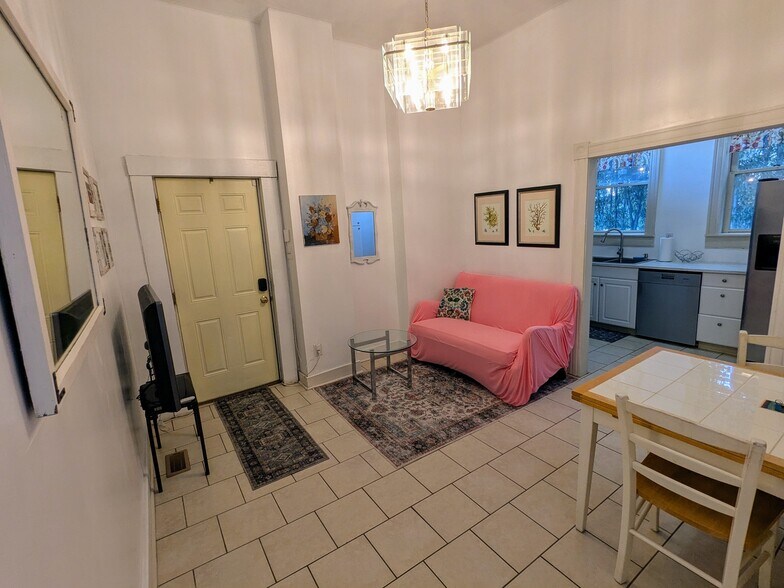 That living hangout area has a nice setup with coffee table, tv... - 1816 W Grace St