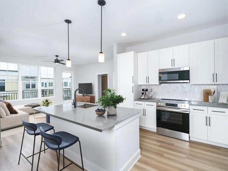 Our alternative option features fresh white cabinets with black hardware, gray quartz counters, and vertical, precious Calacatta Florida tile. - MAA Liberty Row
