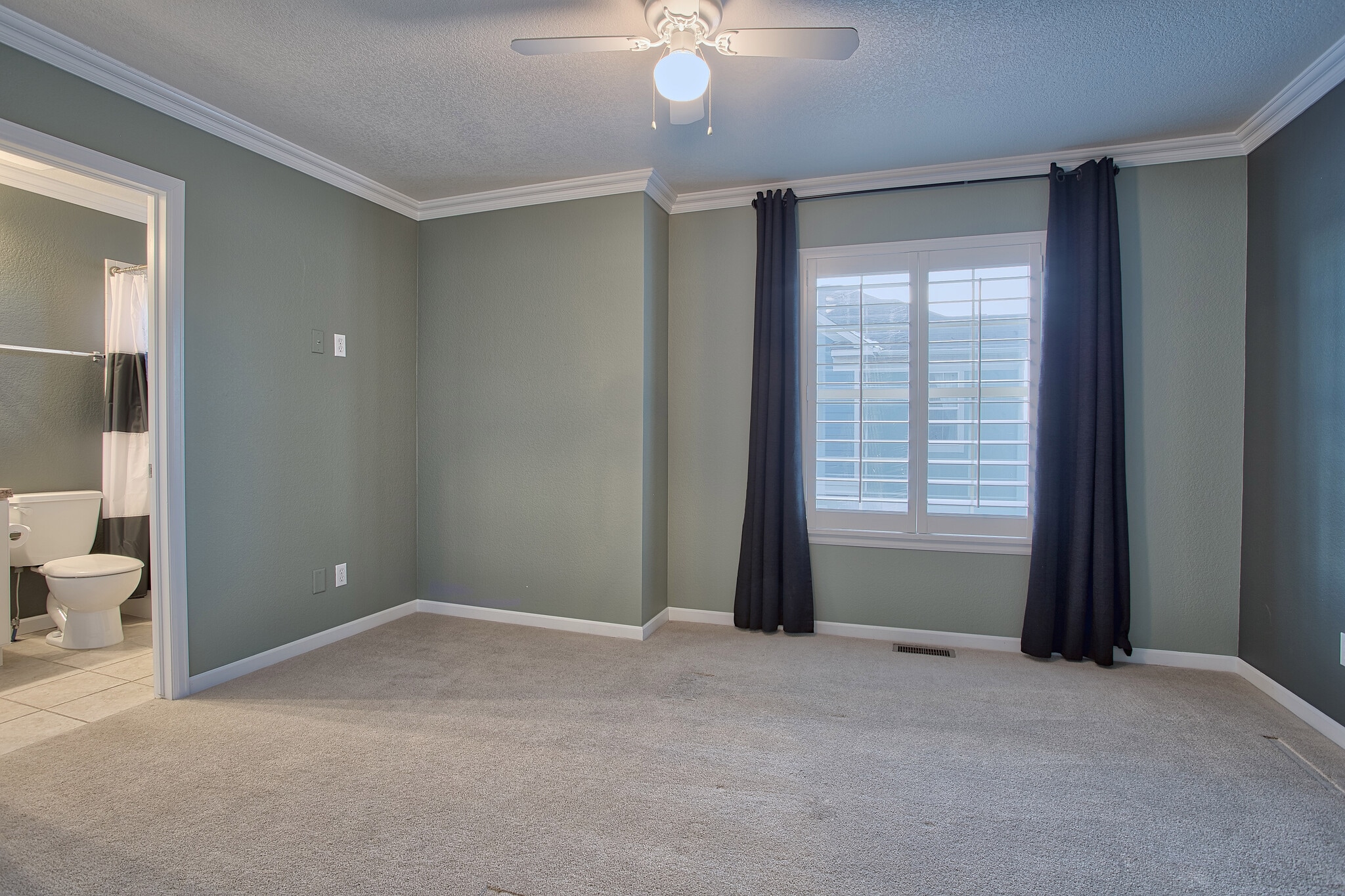 Second bedroom with crown molding, ceiling fan, plantation shutters, and own bathroom - 7422 E 7th Ave Unit 14