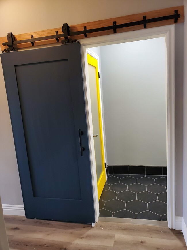 Bathroom entry with antique barn door original to property - 579 W. 13th St